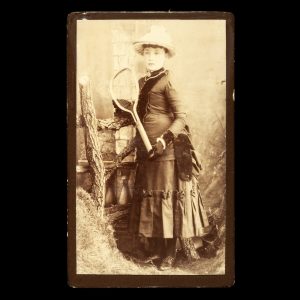 Photographic portrait of a young woman holding a tennis racquet. Ballarat, c.1890.