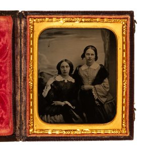 Ambrotype of two sisters holding hands, posed against painted backdrop.
