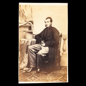 Studio portrait of a gentleman posed with his top hat upturned on a table beside him. Sydney, early 1860s.