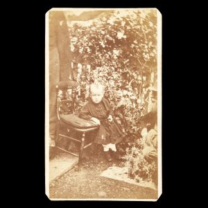 Outdoor portrait of a young boy in a garden, resting his arm on a chair. Hobart Town, c.1862.
