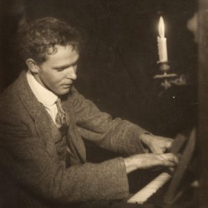 Portrait of photographer and missionary Norman Deck playing the piano. Riley Street, North Sydney, c.1905.